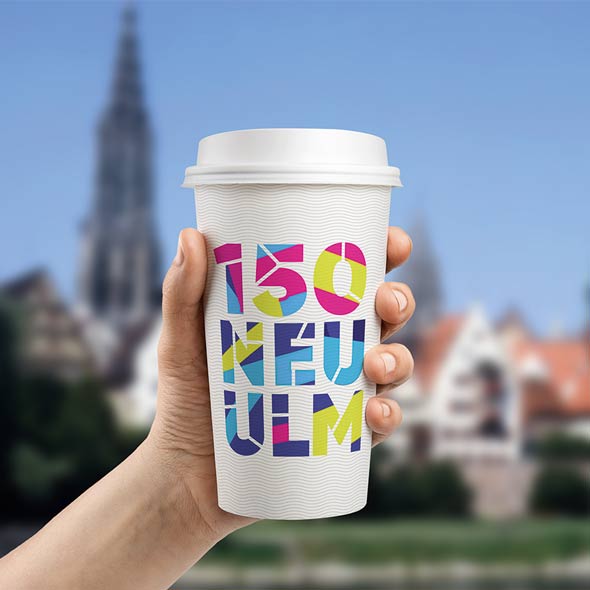 Kaffeebecher mit dem entworfenen 150-Jahre-Neu-Ulm Schriftzug. Konzipiert von der AKSIS Werbeagentur