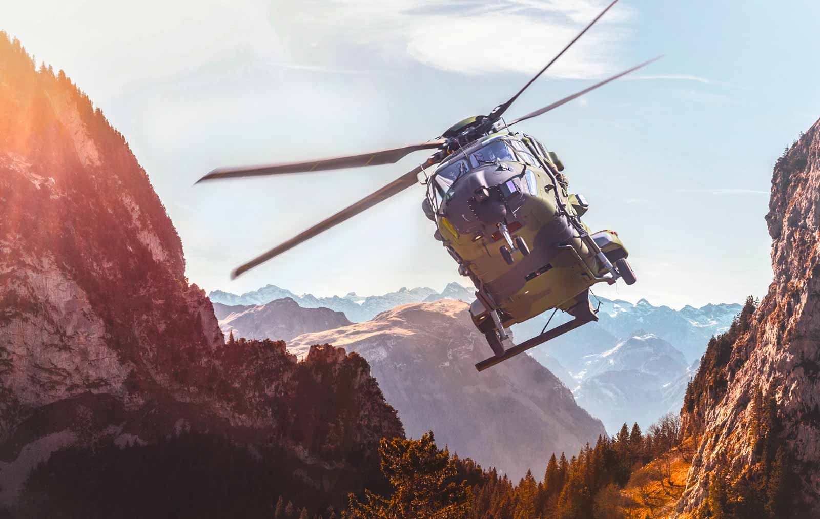 Ein Hubschrauber fliegt durch eine Berglandschaft. Bild von der Website von Spherea Germany